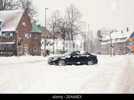 07 February 2021, North Rhine-Westphalia, Münster: A car stands across the road in the snow in the street 'Am Stadtgraben'. Up to 30 centimetres of snow had fallen in East Westphalia and in Münsterland in the night to Sunday within a few hours. Photo: Ute Friederike Schernau/dpa Stock Photo