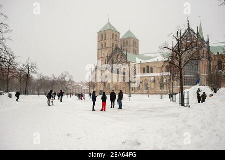 07 February 2021, North Rhine-Westphalia, Münster: People standing in the snow in front of St Paul's Cathedral. Up to 30 centimetres of snow had fallen in East Westphalia and in the Münsterland region in the night to Sunday within a few hours. Photo: Ute Friederike Schernau/dpa - ATTENTION: Use only in full format Stock Photo