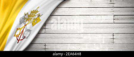 Vatican City flag on old white wall. Horizontal panoramic banner.