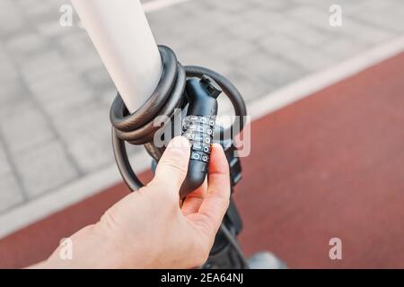 a combination lock on a scooter or bicycle as a symbol of property protection and theft. Stock Photo