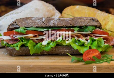 Static shot of a light, turkey bread roll and a dark, balkan sandwich, with sallad Stock Photo