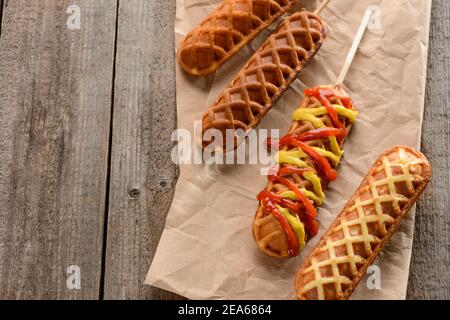 Freshly cooked corn dogs on a wooden table Stock Photo