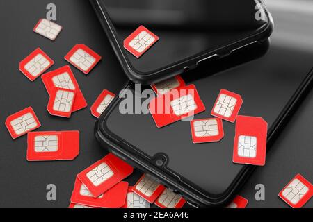 Two cell phones and a lot of SIM cards. The concept of fraud, deception, mass dialing. Stock Photo