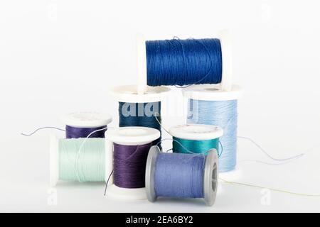 Multicolored Spools of Thread in a pile on white background. Stock Photo