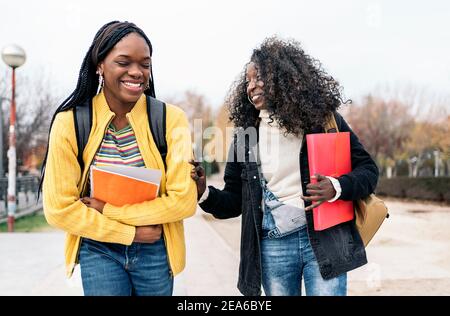 Stock photo of black students talking and laughing in the street. Stock Photo