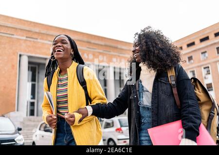 Stock photo of black students talking and laughing after class in college. Stock Photo