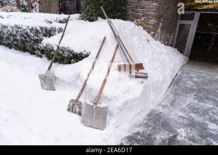 08 February 2021, Lower Saxony, Osnabrück: Snow shovels and brooms lie next to an underground parking garage exit. Photo: Jonas Walzberg/dpa Stock Photo