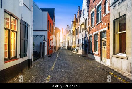 Narrow cobblestone street with traditional houses in medieval city center of Bruges, Belgium. Stock Photo