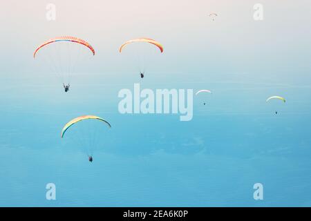 Team of paragliders flying in the blue sky. Takeoff from famous spot on Babadag mountain Stock Photo