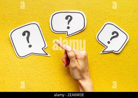 Question mark on speech bubbles with hand, top view. Solution concept Stock Photo