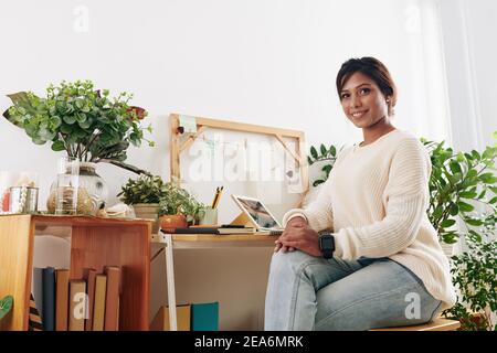 Woman sitting at desk in home office Stock Photo