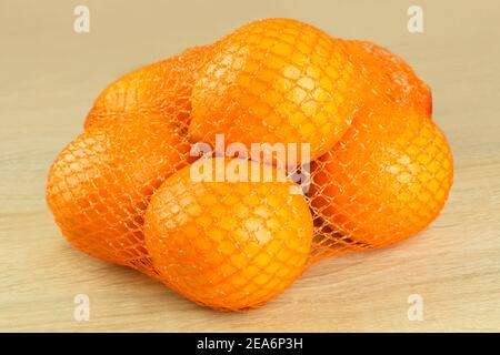 Sieben Orangen im Netz auf Holz