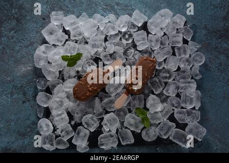 Popsicle chocolate ice cream with almonds on ice cubes background Stock Photo