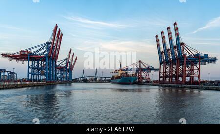 HAMBURG, GERMANY - Aug 08, 2020: Cranes and container ship in the port of Hamburg harbor at sunset Stock Photo