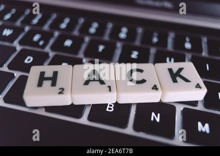 The word "hacked" that is written on the laptop Stock Photo