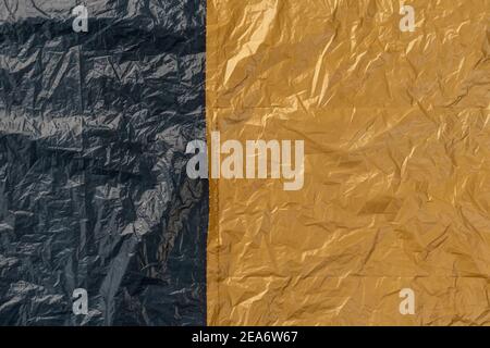 Crumpled wrinkled black beige plastic bag fragment. Abstract texture. Copy space Stock Photo