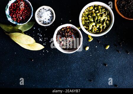 Overhead view of pumpkin seeds, salt, pepper bay leaves and sesame seeds Stock Photo