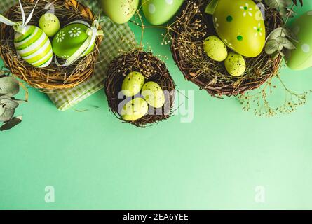 Overhead view of Easter eggs in a bird's nest on a green background Stock Photo