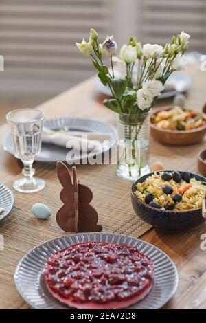Close up background of elegant Easter dinner table set with Spring flowers and delicious homemade food, copy space Stock Photo