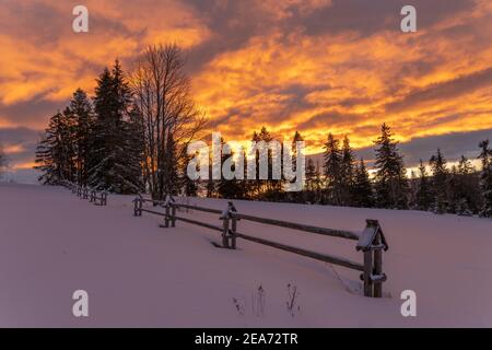 A fiery, dramatic sunrise in a winter mountain scenery Stock Photo