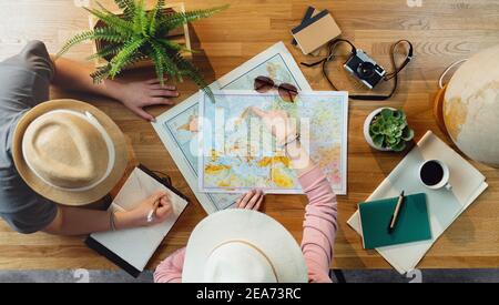 Top view of young couple with maps planning vacation trip holiday, desktop travel concept. Stock Photo