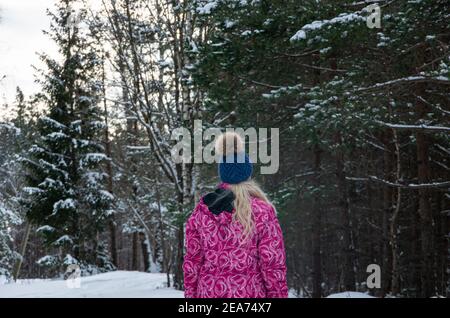 Blonde girl in the forest in winter with a lot of snow, in the forest by car road, white Stock Photo