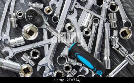 Wrenches on a wooden background. Rattle with a blue handle. Stock Photo