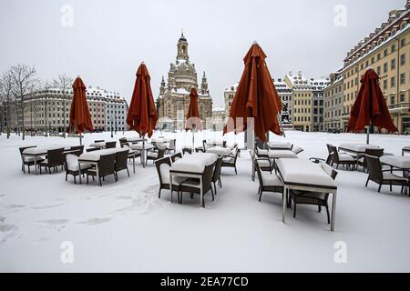 Dresden, Germany. 08th Feb, 2021. Snow-covered are tables and chairs of a restaurant on the Neumarkt in front of the Frauenkirche. Credit: Robert Michael/dpa-Zentralbild/dpa/Alamy Live News Stock Photo