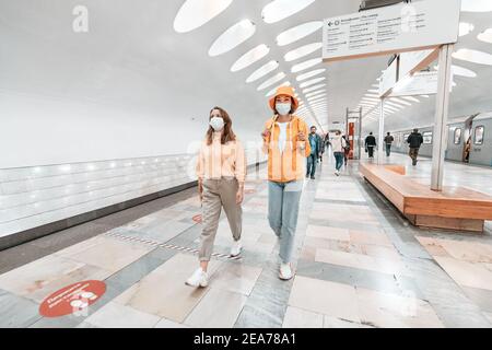 02 September 2020, Moscow, Russia: Two friends walks in medical masks in the Moscow metro. Coronavirus restrictions and quarantine on public transport Stock Photo