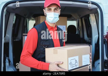 Hispanic delivery man wearing safety mask for coronavirus prevention - Focus on face Stock Photo