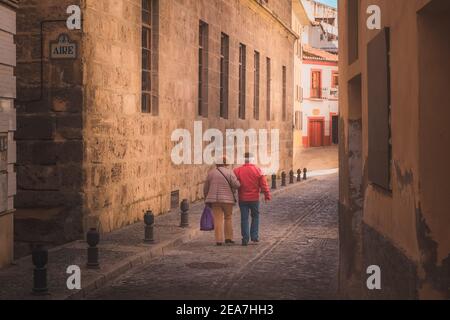 Granada, Spain - April 1 2018: A local elderly couple enjoy a quiet Sunday stroll on the quaint, narrow cobblestone streets in old town (Albaicin or A Stock Photo
