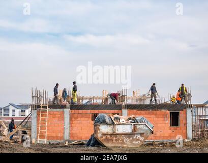 Bucharest, Romania - 01.23.2021: Construction workers building a new house in a residential area, in Bucharest. Stock Photo