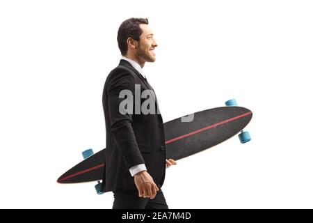 Young businessman in a suit walking and carrying a longboard isolated on white background Stock Photo