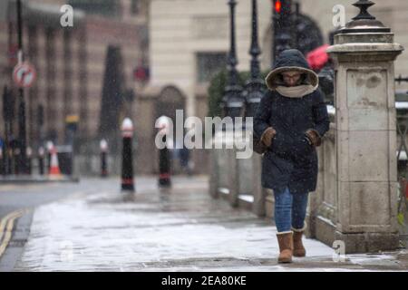 London,UK. 8th Feb 2021. A woman is seen commuting  during a snow shower in Bank, central London. Snow is expected for large parts of the UK and a yellow weather warning is in place in parts of England as Storm Darcy hits the UK. Credit: Marcin Nowak/Alamy Live News Stock Photo