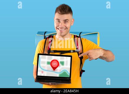 Tourist Guy Showing Laptop With Navigation Map On Blue Background Stock Photo
