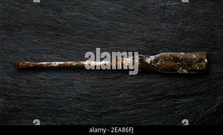 Rusty tool on slate background. Stock Photo