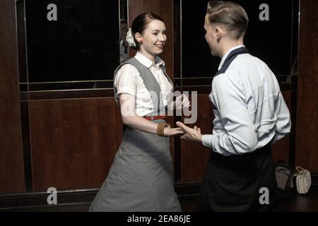 Young couple swing dancing Lindy hopping and jiving to retro 40s 50s music at a club, UK Stock Photo