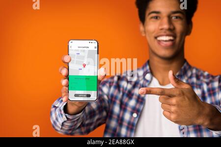 Cheerful African Man Showing Cellphone With Navigation Application, Orange Background Stock Photo