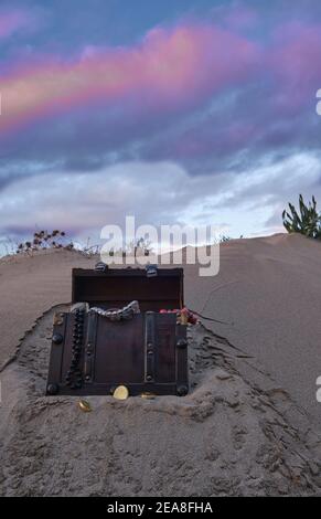 treasure chest at the beach in a sunrise, jewels and gold coins Stock Photo