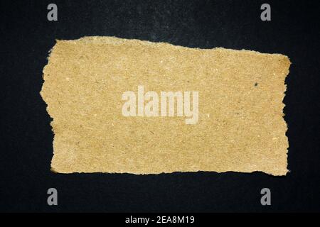 Torn brown paper on a black background, copy space Stock Photo