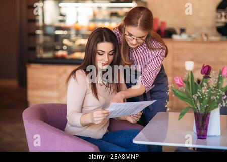 Waitress taking order from her customer in a cafe Stock Photo
