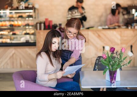 Waitress taking order from her customer in a cafe Stock Photo