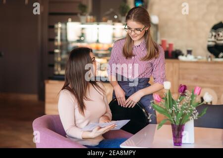 Waitress taking order from her customer in a cafe Stock Photo