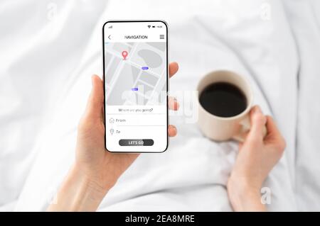 Woman Using Cellphone With Navigation App Browsing Route In Bedroom Stock Photo