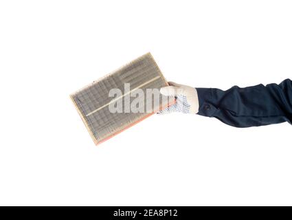 A car locksmith holds in his hand a dirty car air filter on a white background, isolate. Close-up Stock Photo
