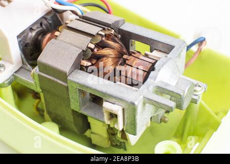 Broken electric motor in a household appliance hand mixer. Malfunction of the rotor and stator of electrical components, close-up, Engineering Stock Photo