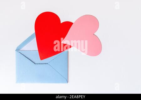 Love letter with hearts. Open blue envelope with big red and pink hearts isolated on white background. Gratitude to doctors and nurses. Valentine's, M Stock Photo
