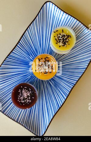 a trio of mini cheesecake desserts in various flavours on a plate close up portrait Stock Photo