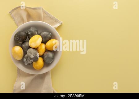 Golden and silver easter eggs in a plate isolated on yellow background Stock Photo