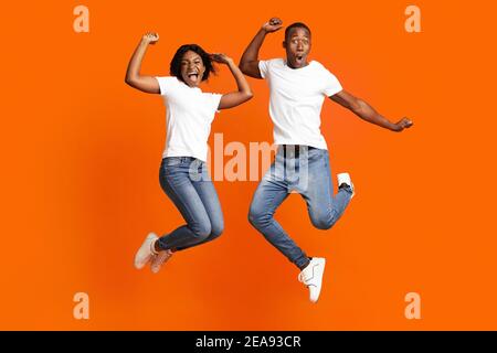 Happy black man and woman celebrating success, full length photo Stock Photo